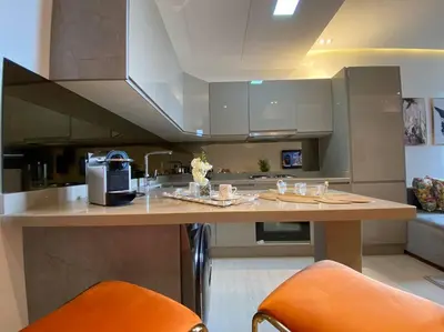 a kitchen with a counter with orange chairs in it at La Corniche- Fab Design Ocean - By AppartAli in Casablanca