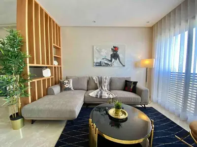 a living room with a couch and a table at Mogador Presidential Terrace - By AppartAli in Casablanca