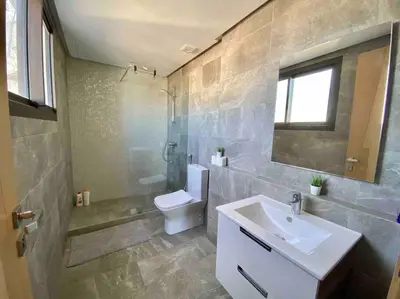 a bathroom with a sink and a toilet and a mirror at Mogador Presidential Terrace - By AppartAli in Casablanca