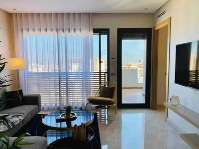 a living room with a couch and a table at Mogador Presidential Terrace - By AppartAli in Casablanca