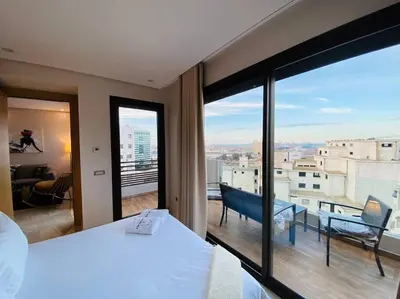 a bedroom with a large window with a view at Mogador Presidential Terrace - By AppartAli in Casablanca
