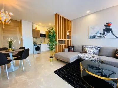 a living room with a couch and a table at Mogador Presidential Terrace - By AppartAli in Casablanca