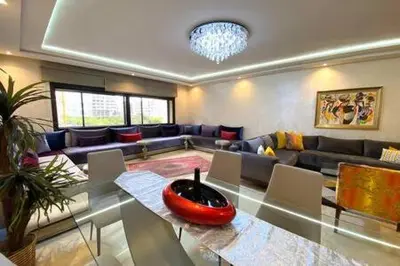 a living room with a couch and a table with chairs at Familial Boulevard D Anfa - By AppartAli in Casablanca