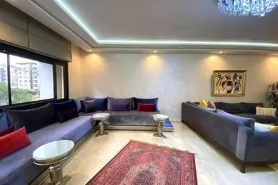 a living room with a blue couch and a large window at Familial Boulevard D Anfa - By AppartAli in Casablanca