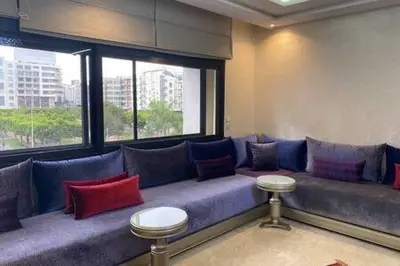 a blue couch with red and blue pillows in a room at Familial Boulevard D Anfa - By AppartAli in Casablanca