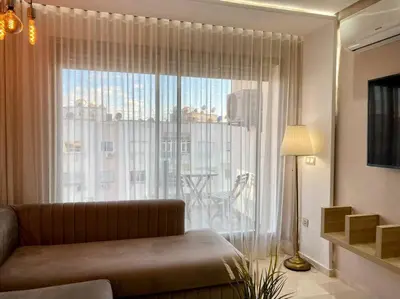 a living room with a couch and a large window at Charming Top Floor Bourgogne - By AppartAli in Casablanca