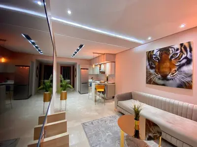a living room with a couch and a tiger painting on the wall at Charming Top Floor Bourgogne - By AppartAli in Casablanca