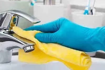 a person wearing a yellow glove is cleaning a sink at Contemporary Top Floor Bourgogne - By AppartAli in Casablanca