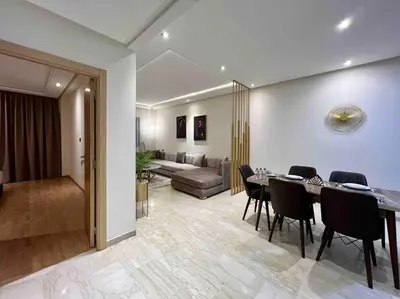 a living room with a table and chairs and a couch at Lovely Anfa City - By AppartAli in Casablanca