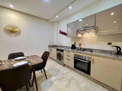 a kitchen with a table and a dining room at Lovely Anfa City - By AppartAli in Casablanca