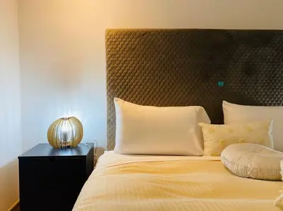 a bedroom with a large bed with a large headboard at Faubourgs D Anfa Suite - By AppartAli in Casablanca