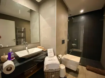 a bathroom with a sink and a toilet and a mirror at Faubourgs D Anfa Suite - By AppartAli in Casablanca