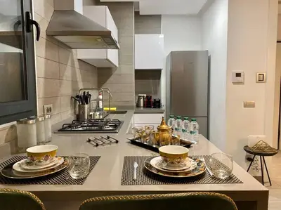 a kitchen with a counter with plates and cups on it at Faubourgs D Anfa Suite - By AppartAli in Casablanca