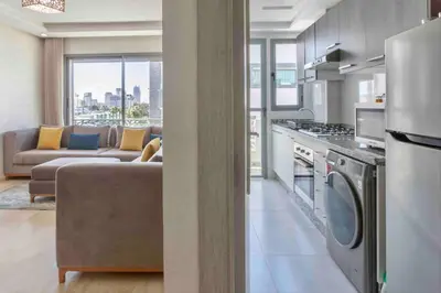 a kitchen and living room with a couch and a stove at Sunny OASIS 2 Bedrooms - By AppartAli in Casablanca