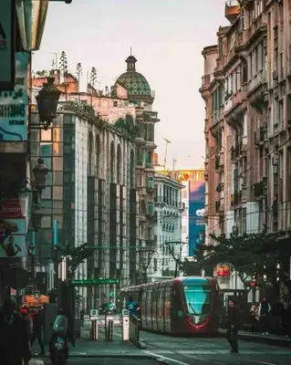 a train on a city street with buildings at Sunny OASIS 2 Bedrooms - By AppartAli in Casablanca