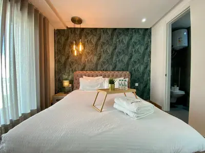 a bedroom with a large bed with a table on it at Racine Zara Street - By AppartAli in Casablanca