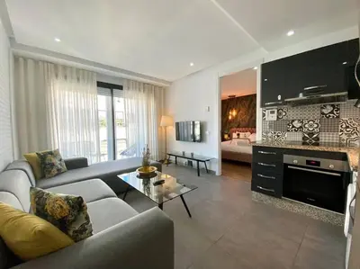 a living room with a couch and a table at Racine Zara Street - By AppartAli in Casablanca