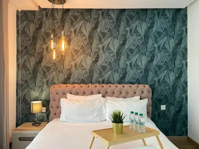 a bedroom with a large bed with a table next to it at Racine Zara Street - By AppartAli in Casablanca