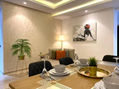 a dining room with a table with chairs and a painting at Maarif City Sunrise- 3 Beds - By AppartAli in Casablanca