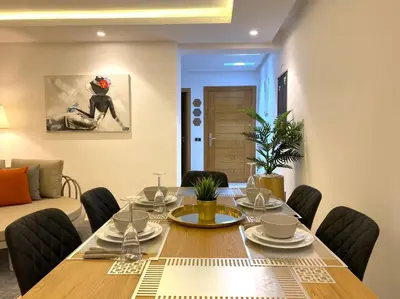 a dining room with a wooden table and chairs at Maarif City Sunrise- 3 Beds - By AppartAli in Casablanca