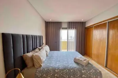 a bedroom with a bed with a blue comforter at Maarif Sunset View - 3 Bedrooms - By AppartAli in Casablanca