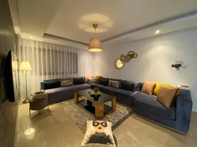 a living room with a blue couch and a table at Maarif Top Floor - 2 Bedrooms - By AppartAli in Casablanca