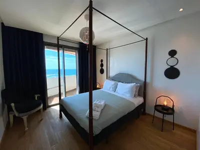 a bedroom with a canopy bed with a view of the beach at The view - Marina 2 Beds - By AppartAli in Casablanca