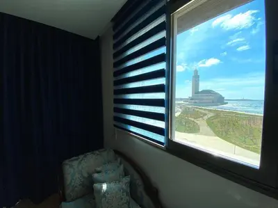 a room with a window with a chair and a view of the ocean at The view - Marina 2 Beds - By AppartAli in Casablanca