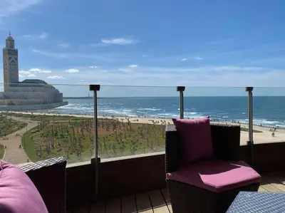 a balcony with a chair and a view of the beach at The view - Marina 2 Beds - By AppartAli in Casablanca