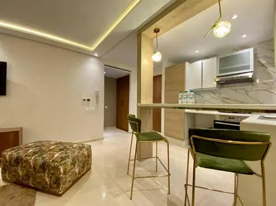 a kitchen with two green chairs and a counter at Deluxe Princesses Design - By AppartAli in Casablanca