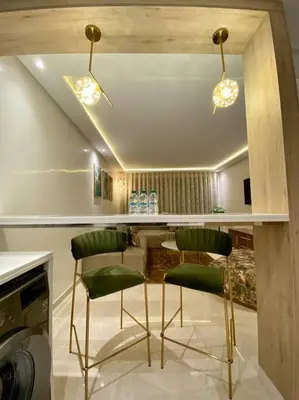 a kitchen with two green chairs and a table at Deluxe Princesses Design - By AppartAli in Casablanca