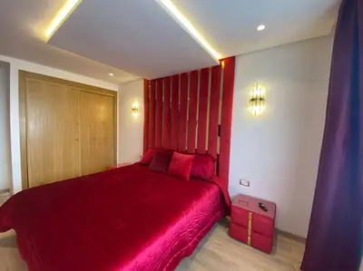 a bedroom with a large red bed with red sheets at Corniche Casablanca - Red’s Neuf in Casablanca