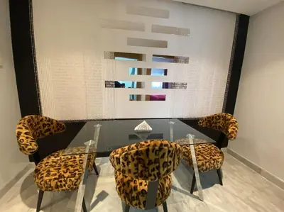 a dining room with a glass table and leopard chairs at Corniche Casablanca - Red’s Neuf in Casablanca