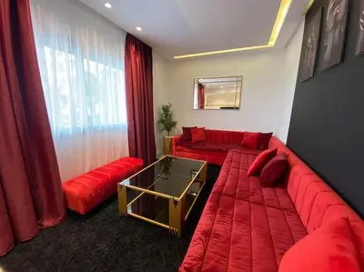 a living room with a red couch and a red sofa at Corniche Casablanca - Red’s Neuf in Casablanca