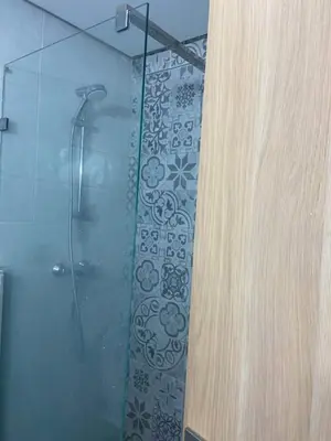 a bathroom with a shower with a glass door at Apartment kamal park E21 in Mohammedia