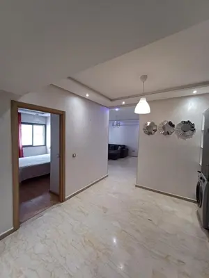 an empty living room with a couch and a window at Apartment kamal park E21 in Mohammedia