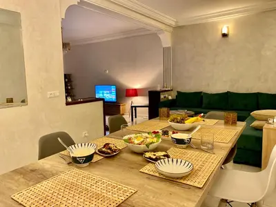 a dining room with a table with bowls of food at Bel appartement avec une belle vue sur la grande mosquée Hassan II et la mer in Casablanca