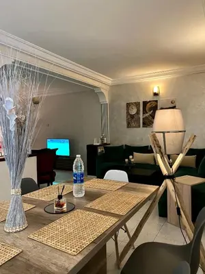 a living room with a table and a couch at Bel appartement avec une belle vue sur la grande mosquée Hassan II et la mer in Casablanca
