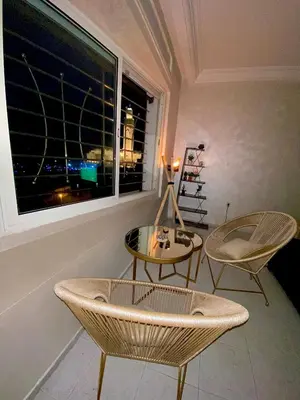 a room with two chairs and a table and a window at Bel appartement avec une belle vue sur la grande mosquée Hassan II et la mer in Casablanca