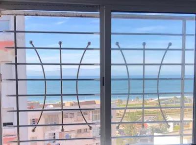 a view of the ocean from a window at Bel appartement avec une belle vue sur la grande mosquée Hassan II et la mer in Casablanca