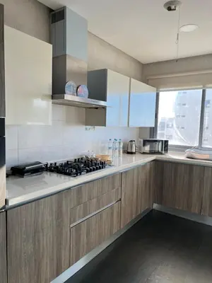 a kitchen with wooden cabinets and a stove top oven at Marina Casablanca Ocean view in Casablanca
