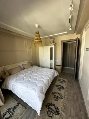 a bedroom with a large white bed and a chandelier at Studio minimaliste marbella beach in Mansouria