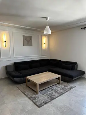 a living room with a black couch and a coffee table at Studio minimaliste marbella beach in Mansouria