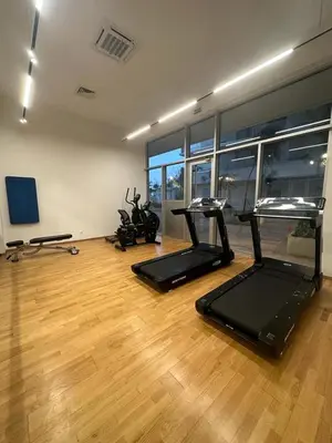 a gym with two treadmills and bikes in a room at Luxury Appt casa finance City CFC-Aeria Mall in Casablanca