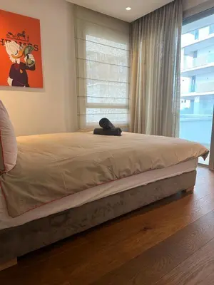 a cat laying on a bed in a bedroom at Luxury Appt casa finance City CFC-Aeria Mall in Casablanca