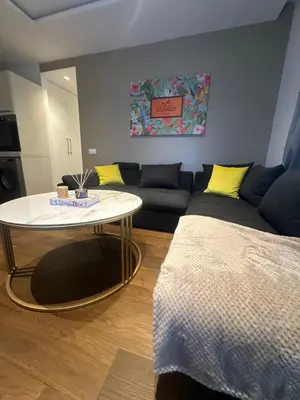 a living room with a table and a couch at Luxury Appt casa finance City CFC-Aeria Mall in Casablanca