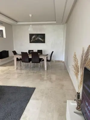 a dining room with a table and black chairs at Chic & cosy Flat Near Airport lockbox fast wifi in Nouaceur