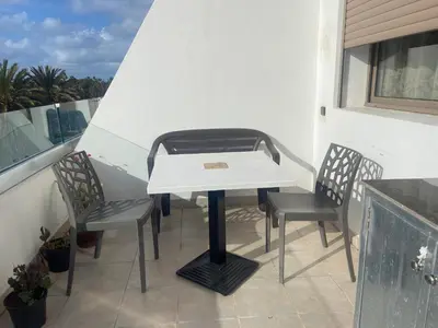 a white table and two chairs on a balcony at Beaulieu du Park commode et paisible in Mohammedia