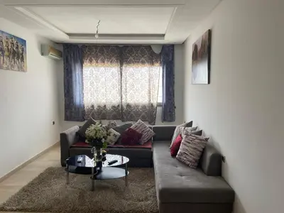 a living room with a couch and a table at Beaulieu du Park commode et paisible in Mohammedia