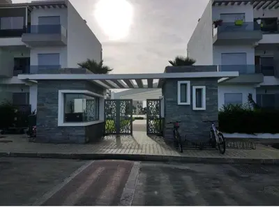 a house with a bike parked in front of it at Grand Apartement a Blanca Beach Sidi Rehal in Sidi Rahal